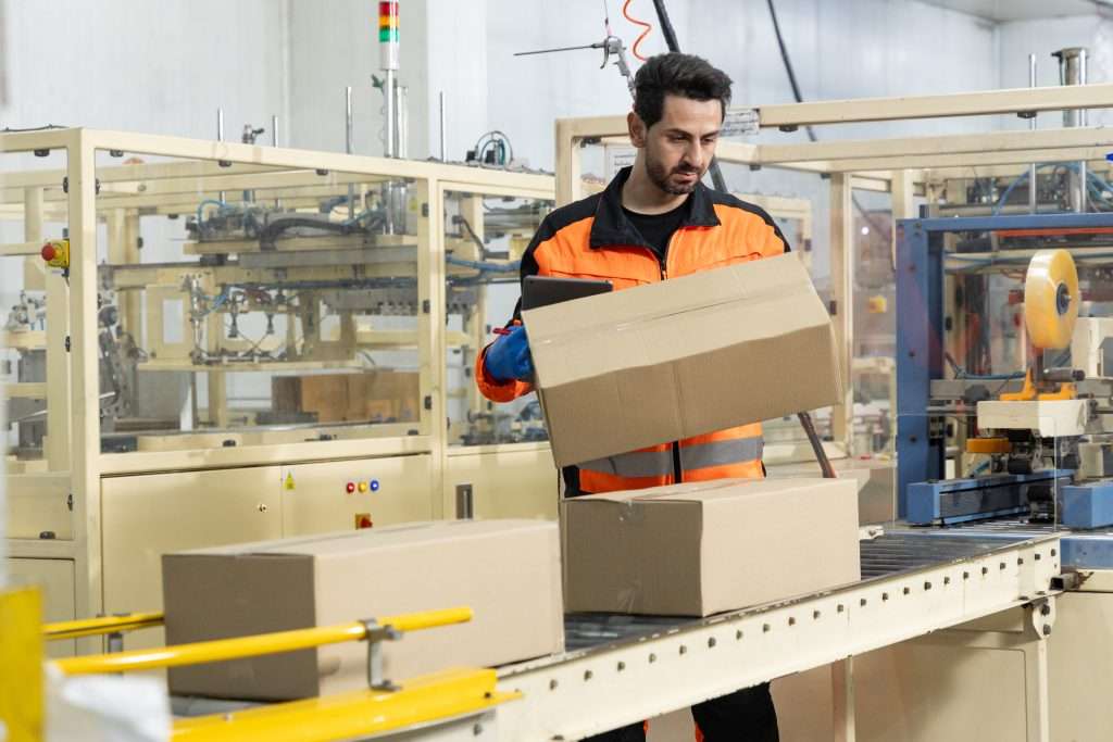 worker performing manual repetitive handling task representing hidden turnover injury and throughput costs of automation status quo